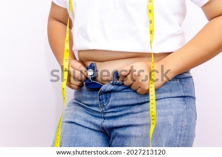 Beautiful fat woman with tape measure She uses her hand to squeeze the excess fat that is isolated on a white background. She wants to lose weight, the concept of surgery and break down fat under 