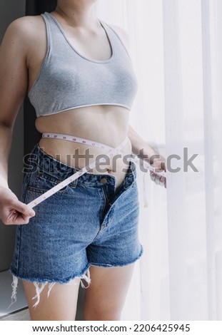 Beautiful fat woman with tape measure She uses her hand to squeeze the excess fat that is isolated on a white background. She wants to lose weight, the concept of surgery and break down fat under the