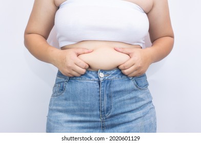 Beautiful fat woman using her hands to squeeze out excess fat that is isolated on a white background. she wants to lose weight The concept of abdominal fat surgery.