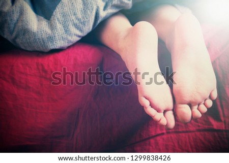 Beautiful feet of a little cute child girl lying in bed close up.  Sleep, morning and relax concept.