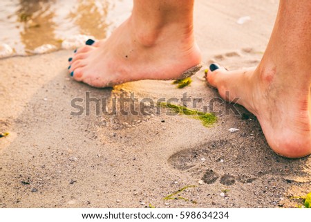 Beautiful feet on the sea sand
