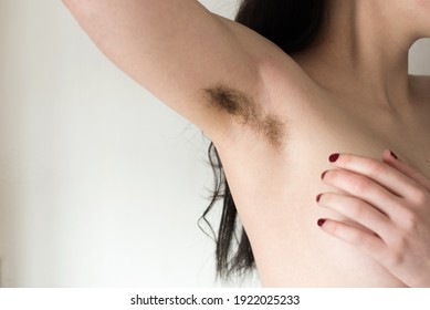 Beautiful female armpits with dark hair. Woman raising her arm and showing unshaven hairy armpits. Bodypositive, feminism and body care concept. - Shutterstock ID 1922025233