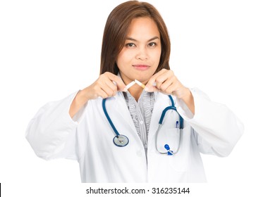 A beautiful female Asian doctor in white lab coat, head angled, looking at camera holds a broken cigarette promoting quitting smoking. Horizontal - Powered by Shutterstock