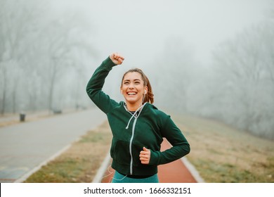 Beautiful Female Athlete With Ponytail Celebrating New Personal Best Time During Running Session.