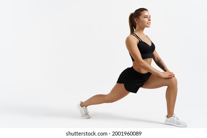 Beautiful female athlete stretching before workout indoors. Sport woman stretch legs, doing gym exercises alone isolated white background, silhouette of girl warming up