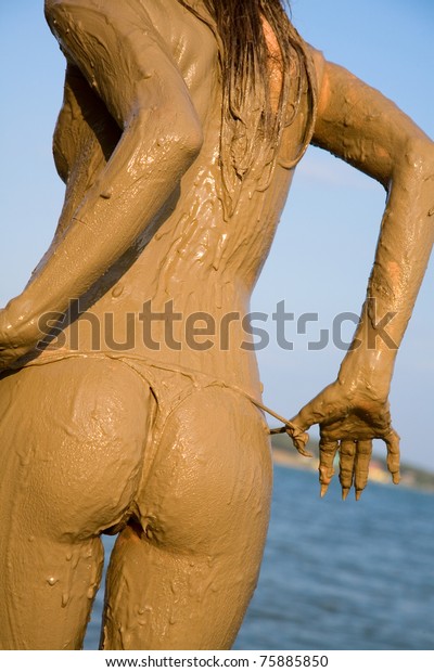 Beautiful female back and buttocks in the mud.