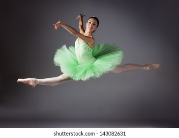 Beautiful female ballet dancer on a grey background. Ballerina is wearing a green tutu and pointe shoes. - Powered by Shutterstock