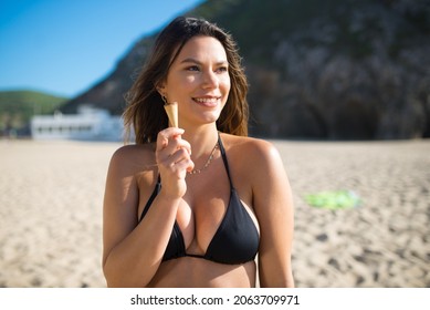 Beautiful Female At Beach Party. Woman In Black Swimsuit, Smiling, Eating Ice Cream. Party, Outdoor Activity, Friendship Concept