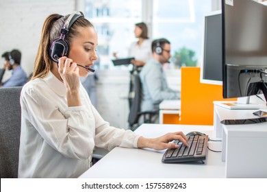 Beautiful female call center operator working on computer in office