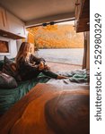 Beautiful Female Camper in RV Van Bed with Doors Open to Remote Lake Landscape Vermont New England Fall Foliage Autumn Season Colorful Digital Nomad