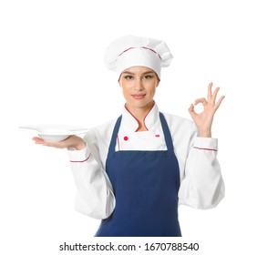 Beautiful female chef with empty plate showing OK on white background