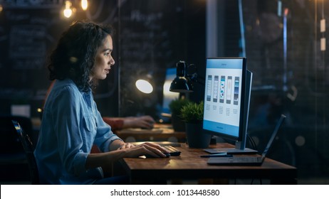Beautiful Female Coder Works at Her Desktop on Her Peropnal Computer. Her Male Colleague Sits Next To Her. Evening Office Has Creative Lighting.