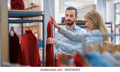 Beautiful Female Customer Shopping In Clothing Store, Retail Sales Associate Helps With Advice. Diverse People In Fashionable Shop, Choosing Stylish Clothes, Colorful Brand With Sustainable Designs