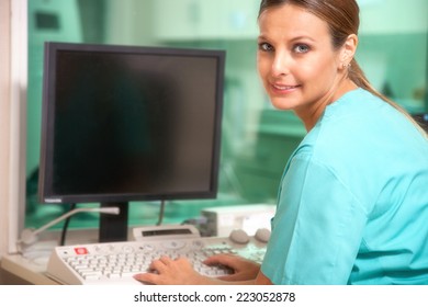 Beautiful Female Doctor Checking Data At Computer Terminal.