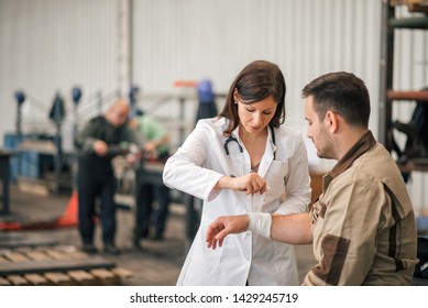 Beautiful Female Doctor Examining Factory Worker.