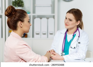 Beautiful Female Doctor Holding Patient's Hand For Encouragement And Empathy And Looking In Her Eyes. Partnership, Trust And Medical Ethics Concept. Bad News Lessening And Support. Patient Cheering