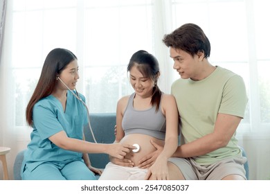 Beautiful female doctor using stethoscope to examine pregnant woman. Medical nurse puts stethoscope on belly of pregnant mother. Happy Asian family receiving checkup and advice from medical staff. - Powered by Shutterstock