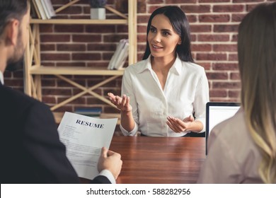 Beautiful female employee in suit is smiling during the job interview