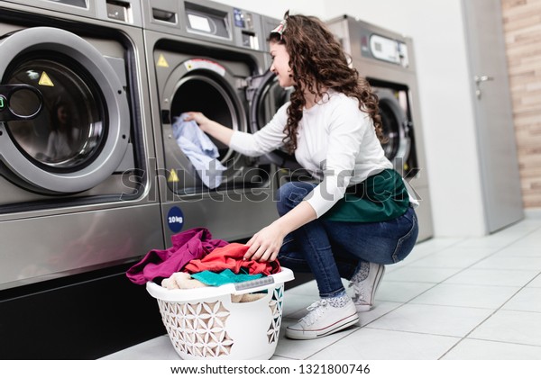 Beautiful\
female employee working at laundromat\
shop.