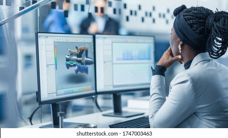 Beautiful Female Engineer Working On Personal Computer In The High-Tech Industrial Factory, She Uses CAD Software Designing 3D Turbine. Over The Shoulder Shot.