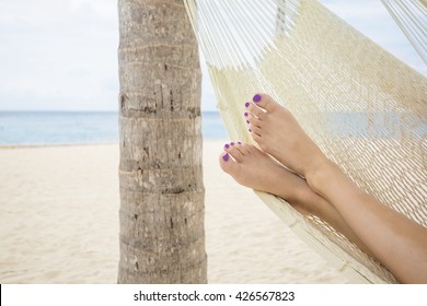 Beautiful female feet in a hammock on the beach at a tropical island resort - Powered by Shutterstock