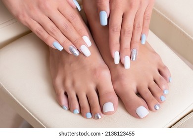 
Beautiful Female Feet And Hands With Stylish Manicure And Pedicure Nails, White, Blue And Silver Gel Polish