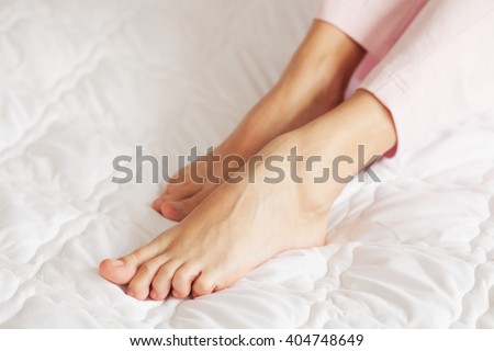 Beautiful female feet on soft blanket