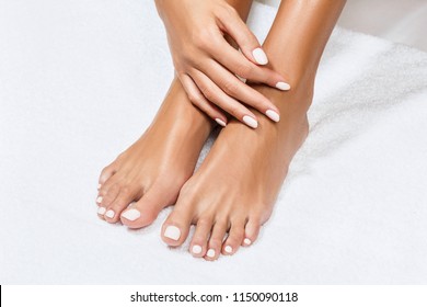 Beautiful female feet over white towel background.