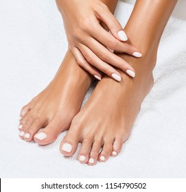 Beautiful Female Feet Over White Towel Background.