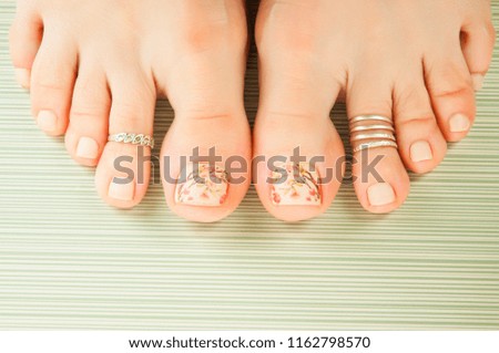 Beautiful female feets with jewelry and fingernail