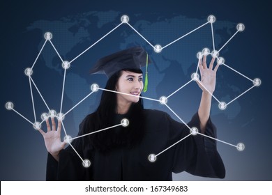 Beautiful female graduate with social network touchscreen concept on blue world map background - Powered by Shutterstock
