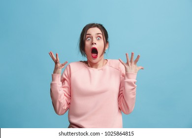 Beautiful female half-length portrait isolated on blue studio backgroud. The young emotional surprised woman standing and looking at camera.The human emotions, facial expression concept. Front view - Shutterstock ID 1025864815