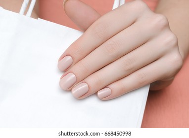 Beautiful female hand with beige nail design.