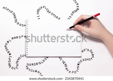 beautiful female hand writes on a white blank notepad, small black letters around the sheet on a white background, free space