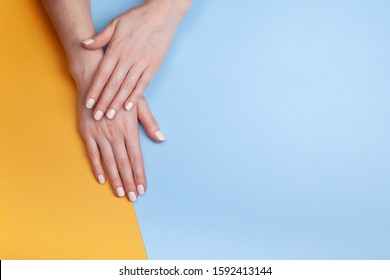 Beautiful female hands with a classic matte manicure on a blue-yellow background. Place for your text. - Shutterstock ID 1592413144