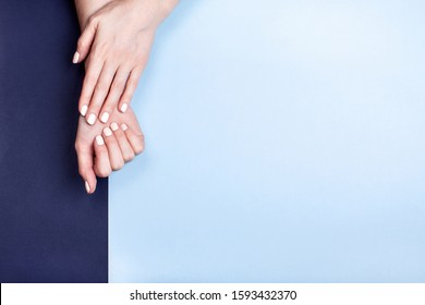 Beautiful female hands with a classic matte manicure on a blue background. Place for your text. - Shutterstock ID 1593432370