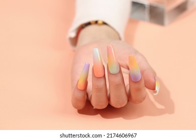 Beautiful female hands with fashion manicure nails, white gel polish, heart design, on pink background with place for text