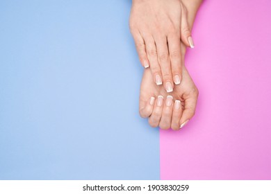 Beautiful Female Hands With French Manicure Over Colorful Paper Background