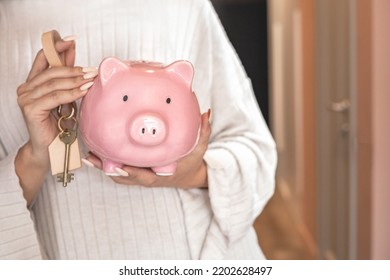 Beautiful Female Hands Holding Pink Piggy Bank With Keys From New House Or Apartment Concept Of Savings And Investment. Woman Arms Carrying Pink Piggybank Investment Financial Economy For Flat Buying