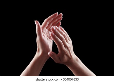 beautiful female hands isolated on black background giving applause