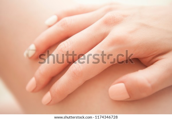 Beautiful\
female hands and manicure of a tender\
shade