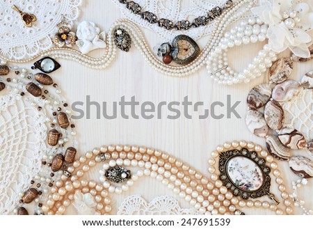 Beautiful female jewelry and trinkets on a light wooden background