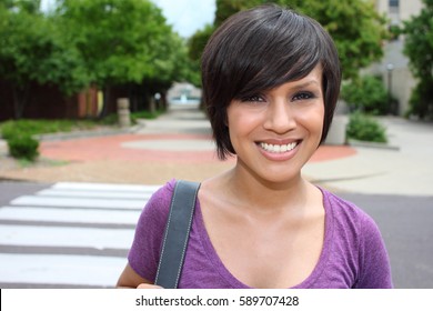 A Beautiful Female Latino Student On A University Campus.