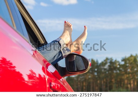 Beautiful female legs in the car window