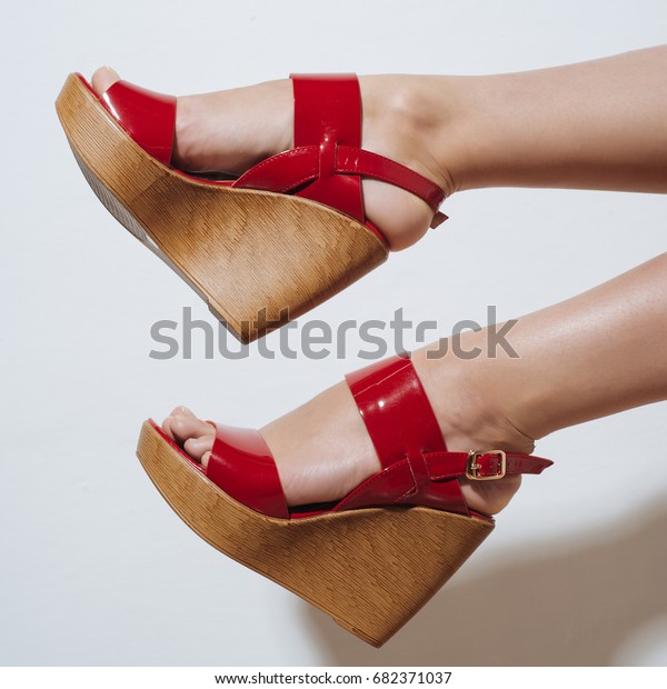 Beautiful female\
legs in red sandals on a\
wedge.