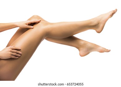 Beautiful female legs touched by hand , isolated on white - Shutterstock ID 653724055