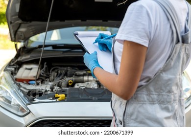 Beautiful Female Mechanic Is Working On A Car Breakdown At A Car Repair Shop. Woman Car Mechanic. Tools In The Hands Of A Woman