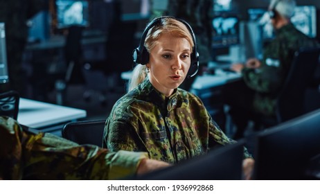 Beautiful Female Military Surveillance Officer In Headset Working In Central Office Hub For Cyber Operations, Control And Monitoring For Managing National Security, Technology And Army Communications.