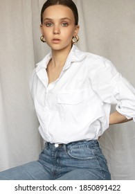 Beautiful Female Model . Beauty Woman . Model Test Portrait With Fashion Girl In Shirt And Jeans On A Textile Background. Natural Makeup And Slick Hairstyle