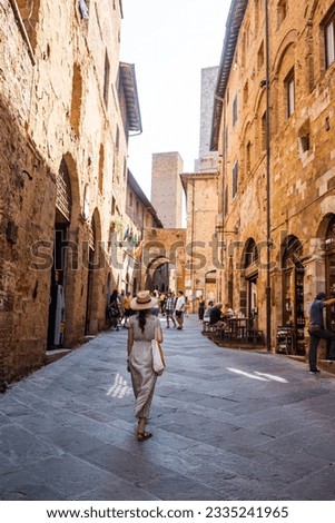 Beautiful female model in historical city of San Gimignano, Italy, Tuscany